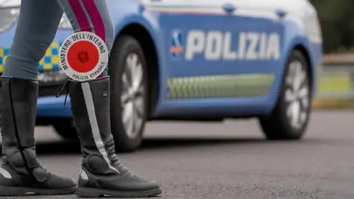 Dettaglio degli stivali di un poliziotto con la paletta infilata dentro, davanti ad una volante della polizia, durante un controllo in strada, in una foto d'archivio. ANSA / POLIZIA DI STATO (simbolica, generica, controlli, polizia, sicurezza, strada)