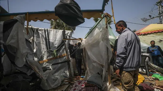 epa11252939 Palestinians inspect a destroyed shelter tents following an Israeli air strike near Al Aqsa hospital, in Deir Al Balah town in southern Gaza Strip, 31 March 2024. Three Palestinian journalists were wounded and two displaced persons were killed in the air strike, according to Palestinian Civilian Defence. More than 32,700 Palestinians and over 1,450 Israelis have been killed, according to the Palestinian Health Ministry and the Israel Defense Forces (IDF), since Hamas militants launched an attack against Israel from the Gaza Strip on 07 October 2023, and the Israeli operations in Gaza and the West Bank which followed it. EPA/MOHAMMED SABER