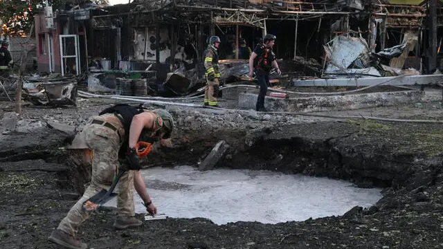 epa11446151 Ukrainian officials inspect a shell crater at the site of shelling in Vilniansk, Zaporizhzhia region, southeastern Ukraine, 29 June 2024, amid the Russian invasion. At least seven people have been killed, including two children, and 18 others injured, including four children, after a Russian rocket strike hit the city of Vilniansk, the State Emergency Service of Ukraine (SESU) said. Russian troops entered Ukrainian territory on 24 February 2022, starting a conflict that has provoked destruction and a humanitarian crisis. EPA/KATERYNA KLOCHKO