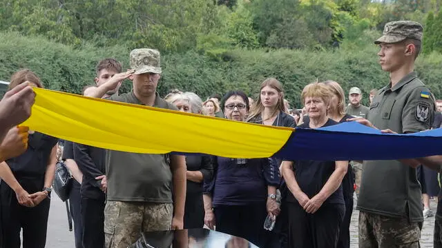epa11527750 Relatives, friends and comrades of late Ukrainian serviceman Sergiy Chornyi attend his funeral ceremony at a cemetery in Kyiv, Ukraine, 05 August 2024. Chornyi, an activist from the 2014 Euromaidan protests, volunteered in the Ukrainian Army and was killed in action near the Chasiv Yar, Donetsk region, on 29 July 2024, amid the ongoing Russian invasion of Ukraine. EPA/SERGEY DOLZHENKO