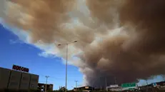 epa11545601 Thick smoke covers the National Highway in Athens from a wildfire that broke out in a farmland and forest area in Varnavas, Attica region, Greece, 11 August 2024. The fire brigade has deployed 165 firefighters, nine teams on foot, 30 vehicles, seven firefighting aircraft, and five helicopters to extinguish the flames. Varnavas residents have been instructed to evacuate the area via a message from the 112 emergency number. EPA/ALEXANDROS BELTES