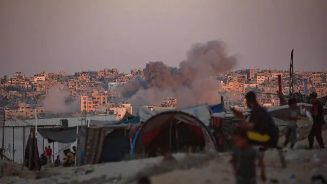 epaselect epa11547886 Smoke rises following an Israeli air strike as internally displaced Palestinians sit next to their tents in Khan Younis camp, southern Gaza Strip, 13 August 2024. More than 39,900 Palestinians and over 1,400 Israelis have been killed, according to the Palestinian Health Ministry and the Israel Defense Forces (IDF), since Hamas militants launched an attack against Israel from the Gaza Strip on 07 October 2023, and the Israeli operations in Gaza and the West Bank which followed it. EPA/HAITHAM IMAD