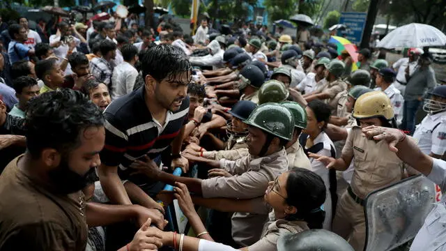 epa11556503 Activists of the right-wing independent all India student organisation Akhil Bharatiya Vidyarthi Parishad (ABVP) try to break a baricade during a march towards the Health Ministry in Kolkata, India 20 August 2024, where they protested against an alleged rape and murder incident. On 09 August a postgraduate medical student was found dead in a seminar room at a hospital, sparking nationwide protests and strikes by medical students and doctors. On 13 August the High Court of Kolkata ruled that the investigation into the rape and murder of a doctor during her working hours at the RG Kar Medical College must be transferred to the Central Bureau of Investigation (CBI). EPA/PIYAL ADHIKARY