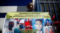 epa11491932 A family member of a young man detained under the state of emergency displays a banner outside the headquarters of the Attorney General's Office in Antiguo Cuscatlan, El Salvador, 22 July 2024. Lawyers from the civil organization Socorro Juridico Humanitario (SJH) accused Minister of Security Gustavo Villatoro and Director of Penitentiary Centers Osiris Luna before the Attorney General's Office on 22 July 2024 for crimes against humanity allegedly committed under the state of emergency, which has been in effect in El Salvador since March 2022 to combat gangs. EPA/Rodrigo Sura