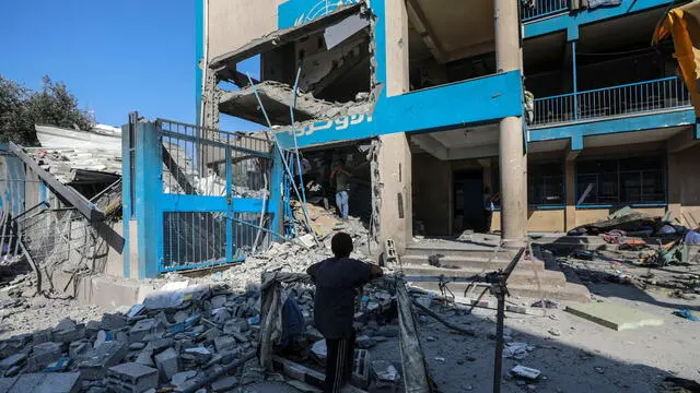 epa11478334 A Palestinian boy stands near the rubble of a damaged UNRWA school following an Israeli air strike in Al Nuseirat refugee camp, central Gaza Strip, 14 July 2024. At least 12 people were killed following an Israeli air strike in the camp, according to the Palestinian Ministry of Health. The Israeli military stated on 14 July, that the Israeli Air Force (IAF) struck the area of UNRWA's Abu Oraiban School School building in Nuseirat, claiming that the location served as a 'hideout and operational infrastructure' to direct and carry attacks against Israeli troops operating in the Gaza Strip. More than 38,000 Palestinians and over 1,400 Israelis have been killed, according to the Palestinian Health Ministry and the Israel Defense Forces (IDF), since Hamas militants launched an attack against Israel from the Gaza Strip on 07 October 2023, and the Israeli operations in Gaza and the West Bank which followed it. EPA/MOHAMMED SABER