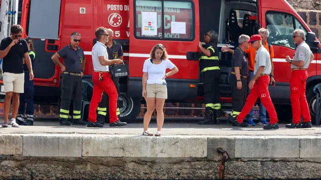 epa11559430 Members of the Fire brigade and the Italian Red Cross wait on the dock as the lifeless body (not pictured) of the fifth missing person is brought to the shore by fire brigade divers, in Porticello, near Palermo, Sicily Island, Italy, 22 August 2024. British tech entrepreneur Mike Lynch's body is the fifth missing one retrieved by divers on 22 August from the wreck of the Bayesian, according to the rescue teams. Lynch's daughter Hannah, 18, remains the only missing passenger. The Bayesian superyacht sank with 22 people on board on 19 August after a tornado hit the area, and 15 passengers were rescued by the coast guard. EPA/IGOR PETYX