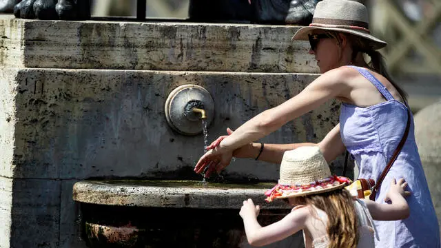 Turisti si riparano dal caldo il giorno di Ferragosto in piazza San Pietro, Roma, 15 agosto 2024. ANSA/ANGELO CARCONI