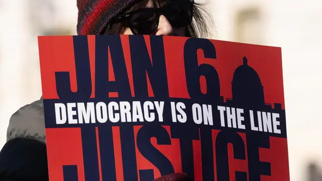 epa11059325 A supporter holds a sign as Democratic lawmakers deliver remarks ahead of the third anniversary of the attack on the Capitol, on Capitol Hill in Washington, DC, USA, 05 January 2024. The third anniversary of the attack on the United States Capitol, when insurrectionists supporting former US President Donald J. Trump attempted to stop the certification of Joe Biden's presidency, takes place 06 January 2024. EPA/MICHAEL REYNOLDS