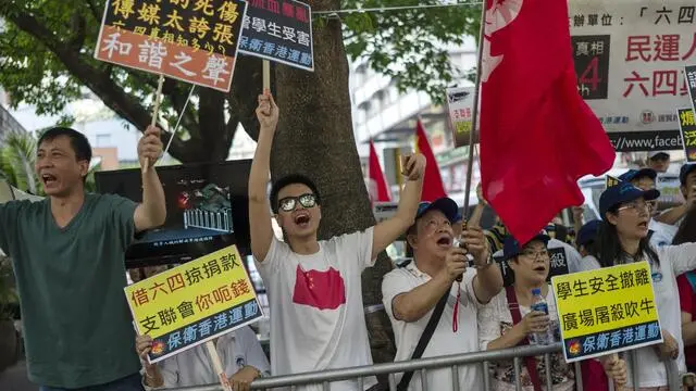 epa05994930 Pro-Beijing supporters wave banners and flags at marchers, unseen, commemorating the 04 June 1989 Beijing Tiananmen Square student massacre, during a protest march in Hong Kong, China, 28 May 2017. The march was organised by the Hong Kong Alliance in Support of Patriotic Democratic Movements of China and precedes an annual June 04 vigil in Victoria Park. The march took place a day after China's number 3 state leader Zhang Dejiang told Hong Kong not to confront Beijing, and called on the Hong Kong government to enact controversial national security laws against treason, sedition and other national threats. EPA/JEROME FAVRE