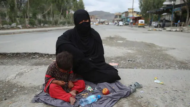 epa09136952 An Afghan woman begs for alms on a roadside in Jalalabad, Afghanistan, 15 April 2021. Civilian casualties in Afghanistan increased by 29 percent between January and March compared to the same period in 2020, despite an ongoing peace talks between the Taliban and the government, according to a report by the United Nations Assistance Mission in Afghanistan (UNAMA) on 14 April. UNAMA in its report also underlined a 37 percent increase in the number of women killed and injured, and a 23 percent increase in child casualties compared with the first quarter of 2020. EPA/GHULAMULLAH HABIBI