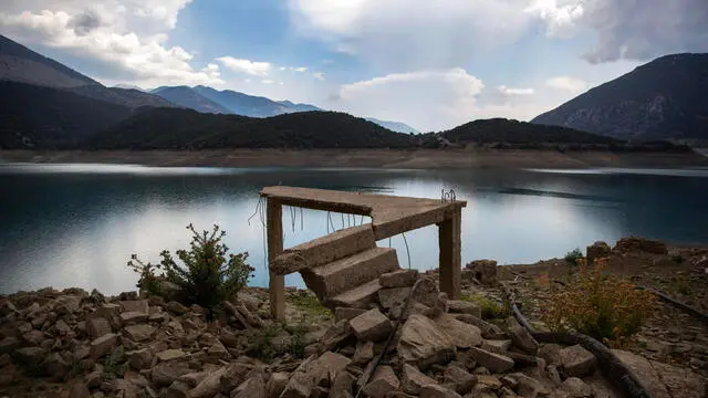 epa11575341 The remains of a house of the sunken village of Kallios is revealed due to the receding water level of Mornos artificial lake, near the village of Lidoriki in the prefecture of Fokida, about 240 km northwest of Athens, Greece, 29 August 2024 (issued 31 August 2024). Over the past two years, the level of Mornos artificial lake, which serves as a water supply to the capital Athens, has receded more than 35 meters, with approximately 18 just the past year, according to local residents. In 1980 when the Mornos lake was completed by constructing a dam in Mornos River, 80 houses along with their church and primary school of the village of Kallio, were evacuated and submerged in the water for the lake to be created. Nowadays, the few residents living around the lake observe with alarm every day how the buried village emerges, along with their childhood memories and everything they left behind. EPA/YANNIS KOLESIDIS