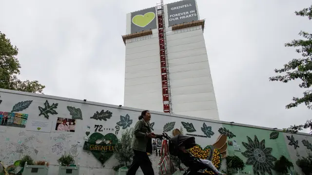 epa11579934 People walk past the Grenfell Tower Memorial Wall near the Grenfell Tower in Kensington, London, Britain, 02 September 2024. The Grenfell Inquiry Phase 2 is set to be published on 04 September 2024. It will examine the conditions that allowed the fire to spread at the 24-storey Grenfell Tower apartment block fire on 14 June 2017 which claimed the lives of 72 people. EPA/TOLGA AKMEN