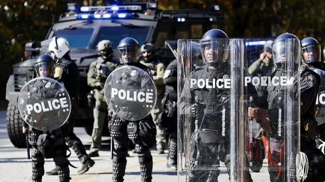 epa10973478 Atlanta police officers in riot gear gathered in response to demonstrators protesting at the construction site of the Atlanta Public Safety Training Center, known as Cop City, in the South River Forest area near Atlanta, Georgia, USA, 13 November 2023. The group is opposed to the construction of the combined training facility for the Atlanta Police Department and Atlanta Fire Rescue Department. An environmental activist has been killed and dozens of protesters have been charged with state RICO charges since the movement began. EPA/ERIK S. LESSER