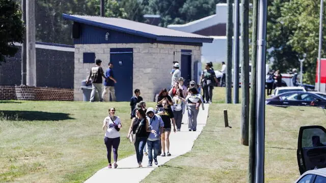 epa11585108 People walk near the scene of a shooting at Apalachee High School in Winder, Georgia, USA, 04 September 2024. At least four people died and nine injured after a shooting at the school, the Georgia Bureau of Investigation (GBI) announced on social media platform X, formerly Twitter, adding that one suspect was in custody. EPA/ERIK S. LESSER