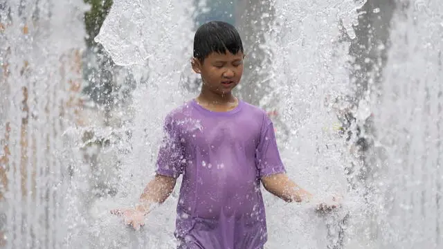 epa11549492 A child cools off in a fountain in Gwanghwamun square in Seoul, South Korea, 15 August 2024. A heat wave continues to affect all areas of South Korea, with temperatures rising to an intra-day high of 36 degrees Celsius in the South Korean capital. EPA/JEON HEON-KYUN