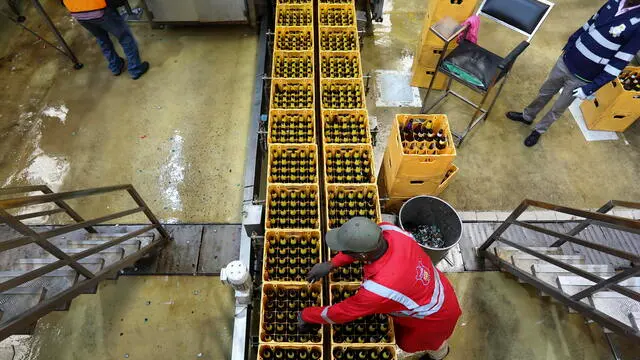 epa09915225 Workers inspect beer bottles in crates on a conveyer belt at the East African Breweries Plc plant at Ruaraka, in Nairobi, Kenya, 28 April 2022. This Year the East African Breweries Plc will be celebrating its 100 years since its establishment in 1922. EPA/DANIEL IRUNGU