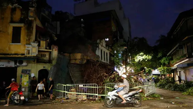 epa11589510 A man rides a motorbike past a fallen tree which blocks a street due to the strong wind in Hanoi, Vietnam, 06 September 2024. Typhoon Yagi is expected to make landfall in northern Vietnam on 07 September, according to the National Center for Hydro-Meteorological Forecasting. EPA/LUONG THAI LINH