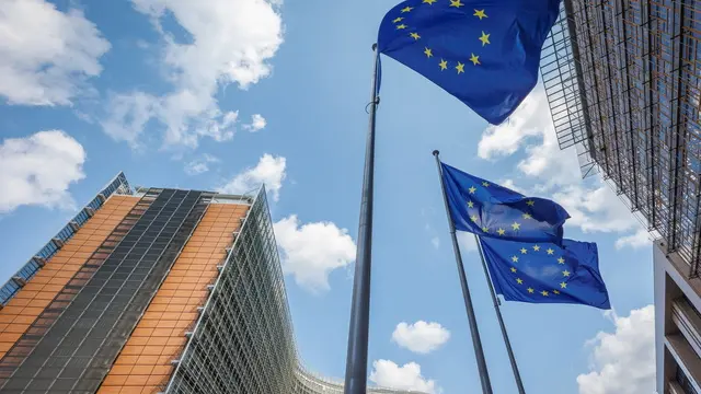 epa11483897 European Union flags flutter in front of the European Commission Berlaymont building (L), in Brussels, Belgium, 17 July 2024. The European Parliament is scheduled to vote on 18 July on Ursula von der Leyen's second term as EU Commission President. EPA/OLIVIER MATTHYS