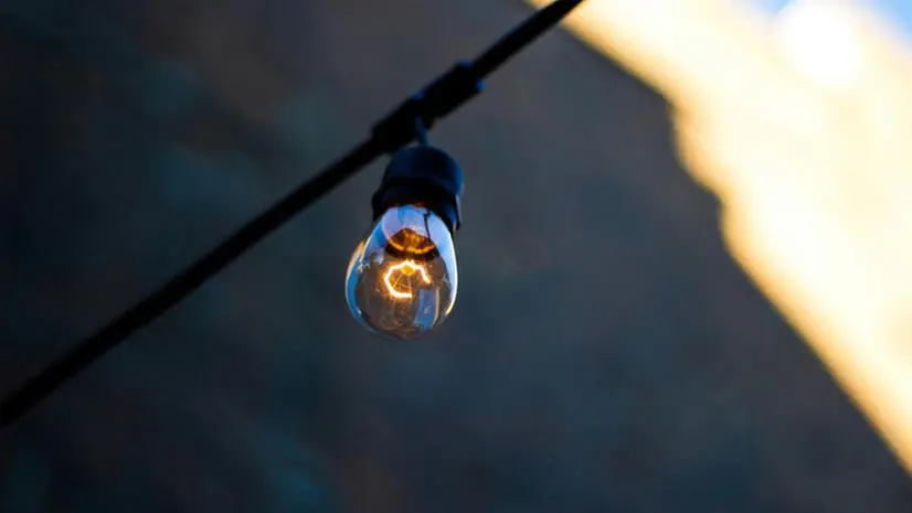 Una lampadina appesa a un filo - Foto Unsplash © www.giornaledibrescia.it