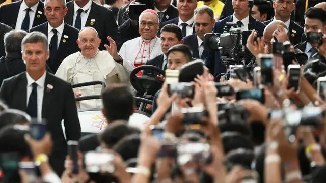 Pope Francis (C) gestures to Catholic faithful as he arrives to lead a holy mass at the National Stadium in Singapore 12 September 2024. ANSA/ALESSANDRO DI MEO