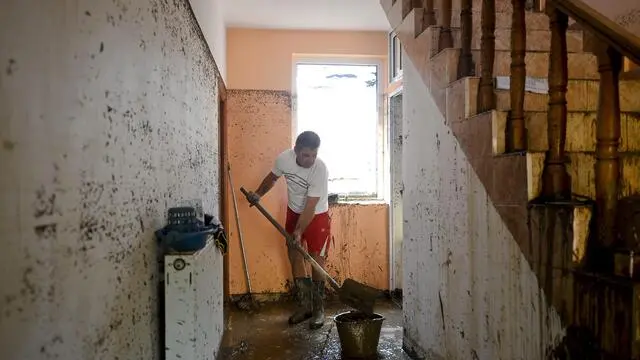 epa04336299 A picture made available 31 July 2014 shows a man cleaning up the water and mud from his family house in the flooded village of Bascov, Arges, Romania, 30 July, 2014. According to reports, more than 1,000 people were evacuated by 2,200 emergency workers, 63 villages from ten counties being affected by floods after heavy rains hit south-eastern Romania. About 400 houses were destroyed, one person died and four others are missing, authorities said. EPA/OCTAV GANEA ROMANIA OUT