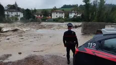 Un carabiniere monitora l'innalzamento di un corso d'acqua in Emilia-Romagna