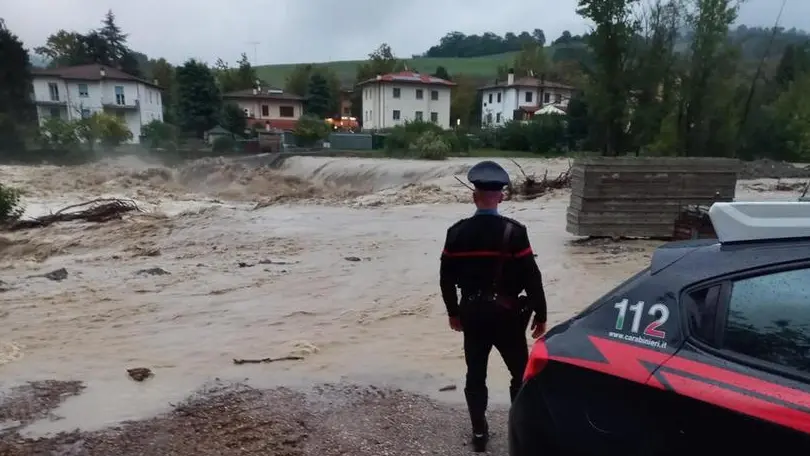 Un carabiniere monitora l'innalzamento di un corso d'acqua in Emilia-Romagna