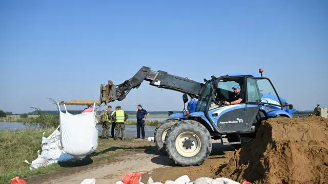 epa11611530 Polish soldiers stand next to an excavator working to reinforce the flood embankments in the village of Marcinkowice, near Olawa, in the Lower Silesian Voivodeship, southwestern Poland, 18 September 2024. Emergency services, such as the fire department and territorial defense forces, are working to reinforce the flood barriers as a flood wave is passing through Olawa. A low-pressure system named Boris brought heavy rain to central Europe between 11 and 15 September? 2024, causing widespread flooding? in central and eastern Europe. EPA/MACIEJ KULCZYNSKI POLAND OUT