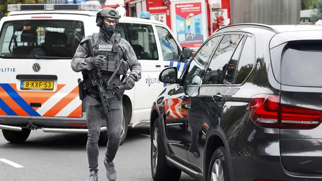 epa10887852 A police officer from the special intervention service walks outside the Erasmus MC Rotterdam hospital on Rochussenstraat, which has been cordoned off after two shooting incidents in Rotterdam, Netherlands, 28 September 2023. An unknown person wearing combat clothing shot at people first in an apartment and after in the hospital, the police announced. EPA/BAS CZERWINSKI