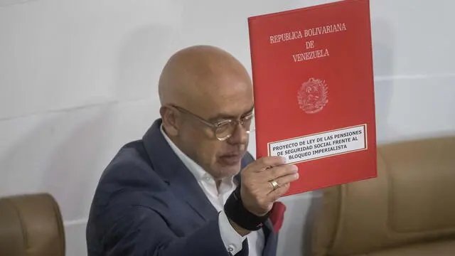 epa11315595 President of Venezuela's National Assembly Jorge Rodriguez holds a bill during a session of the assembly in Caracas, Venezuela, 02 May 2024. Venezuela's National Assembly, with a large pro-government majority, approved on May 2 the creation of a law proposed by Executive Vice President Delcy Rodriguez which aims, according to authorities, to protect pensions against the effects of the 'criminal blockade' imposed by the United States. EPA/MIGUEL GUTIERREZ