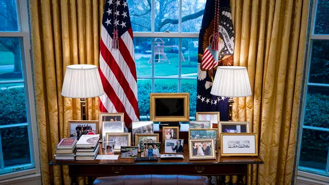 epa09831479 Family photos sit behind the Resolute desk, used by US President Joe Biden (not pictured), while meeting virtually with Micheal Martin, Ireland's prime minister, in the Oval Office of the White House in Washington, DC, USA, 17 March 2022. Martin tested positive for Covid-19 while in Washington for St. Patrick's Day celebrations. EPA/AL DRAGO / POOL