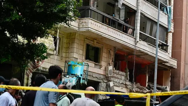 epaselect epa11616046 People gather in front of a damaged building after an Israeli military strike, in Beirut, Lebanon, 20 September 2024. At least three people have been killed in the attack, which targeted the southern suburb of Beirut, according to the Lebanese Ministry of Health. The Israeli military stated on 20 September that it conducted a 'targeted strike' in Beirut, claiming that the 'Hezbollah Commanders we eliminated today' had been planning attacks on northern areas of Israel. EPA/WAEL HAMZEH