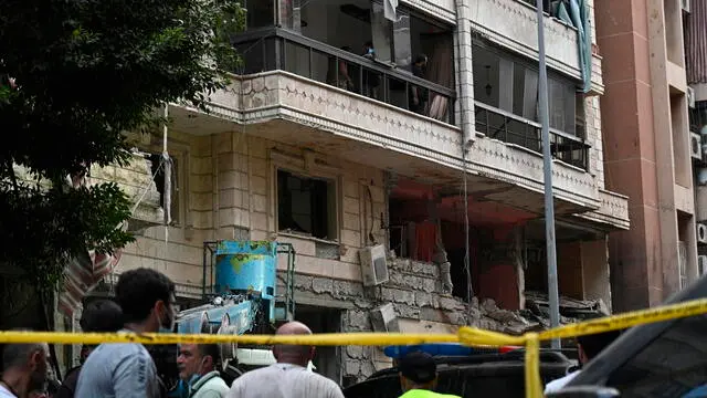 epa11616191 People gather in front of a damaged building after an Israeli military strike, in Beirut, Lebanon, 20 September 2024. At least eight people were killed and dozens injured in the attack, which targeted the southern suburb of Beirut, according to the Lebanese Ministry of Health. The Israeli military stated on 20 September that it conducted a 'targeted strike' in Beirut, claiming that the 'Hezbollah Commanders we eliminated today' had been planning attacks on northern areas of Israel. EPA/WAEL HAMZEH