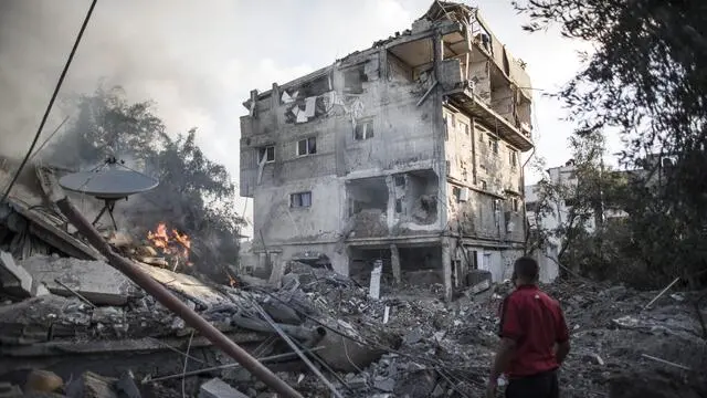 epa04318027 A Palestinian man looks at a house destroyed by Israeli Defense Forces during an overnight air strike in Gaza City, 16 July 2014. Reports on 16 July 2014 state that Israel has bombed at least 30 targets in the northern Gaza Strip, after telling more than 200,000 residents they should evacuate the town of Beit Lahiy and the Gaza City neighbourhoods of Sheja'iya and Zeitoun. EPA/OLIVER WEIKEN