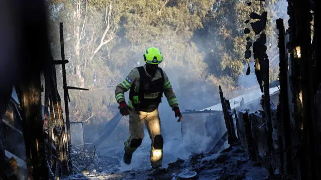 epa11617817 A firefighter douses a fire coming from projectiles fired from south Lebanon near Safed, northern Israel, 21 September 2024. The Israeli Defense Forces (IDF) said that "approximately 90 projectile launches were identified crossing from Lebanon into Israeli territory." Furthermore, the Air Force "struck thousands of launcher barrels that were ready for immediate use to fire toward Israeli territory." EPA/ATEF SAFADI