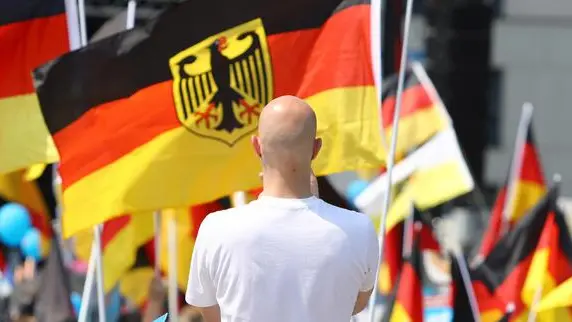 epa06766530 A skinhead man in front of German flags during a gathering of the 'Alternative for Germany' (AfD) party in Berlin, Germany, 27 May 2018. The AfD has called for a large demonstration according to the motto 'Future Germany' (Zukunft Deutschland) to which they expect more than 5,000 participants. Various alliances of parties, cultural workers and civil society have organized counter-demonstrations and rallies, which are also expected to attract more than 10,000 participants. EPA/OMER MESSINGER