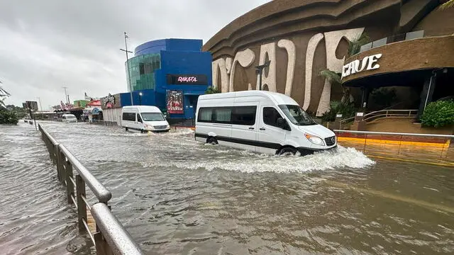 epa11625168 Cars cross a street flooded by Hurricane Helene in the beach resort of Cancun, Quintana Roo, Mexico, 25 September 2024. The northern part of the state of Quintana Roo in southern Mexico was hit by Hurricane Helene, which intensified to a category 1 hurricane in the Caribbean Sea as it heads towards the United States. EPA/Alonso Cupul