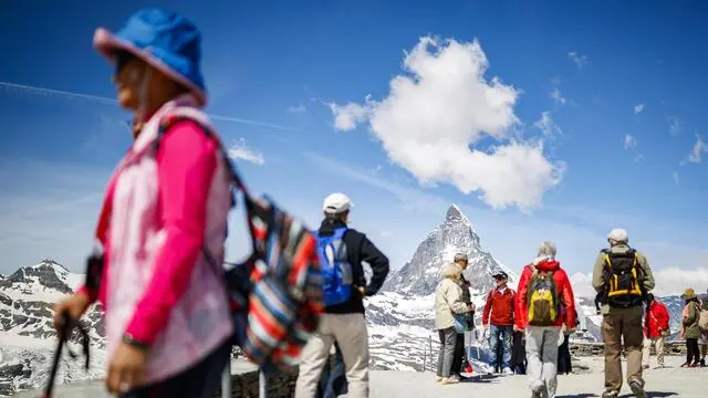 epa06830570 Tourists enjoy the view in front of the the iconic Matterhorn mountain, peaking at 4478m, from the Gornergrat viewpoint above the alpine village of Zermatt, Switzerland, 22 June 2018. EPA/VALENTIN FLAURAUD