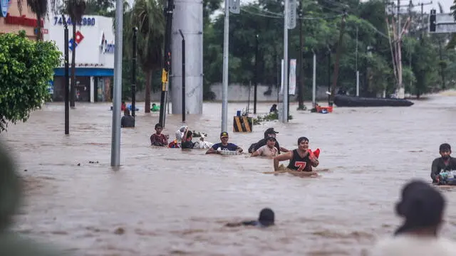 epaselect epa11629594 People cross an avenue flooded by the passage of Hurricane John in the upper part of the port of Acapulco, in Guerrero, Mexico, 27 September 2024. Mexican authorities reported another six deaths from Hurricane John, bringing the death toll to 22 since the cyclone's impact, of which 18 are in the southern state of Guerrero, another three in neighboring Oaxaca, and one more in Michoacan. EPA/DAVID GUZMAN