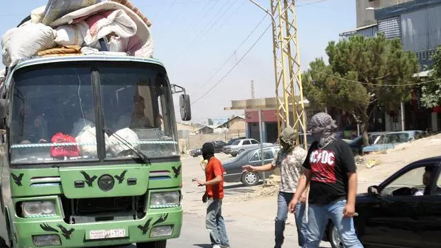 epa03363157 Members of a Lebanese Salafist group inspect a Syrian vehicle at a checkpoint in Majdal Anjar, near the Lebanese-Syrian border, eastern Lebanon, 16 August 2012. A group of masked Sunni youths set up barriers on the main road in Majdal Anjar, reportedly known for protecting Sunni fundamentalist fugitives, to the Lebanon-Syria al-Masnaa border crossing, carrying out ID checks before deciding whether to let them pass. A spokesman for the group, Ali Abdul Khaliq, said their action was in response to the recent kidnappings of Sunnis by Shiites in Beirut. Arab countries, including Saudi Arabia, Kuwait, Qatar and the United Arab Emirates, on 16 August started evacuating their citizens from Lebanon over a series of kidnappings of Sunni Muslim foreigners by a Lebanese Shiite clan demanding the release of one of its members held by Syrian rebels. The kidnappings raised fears that the Syrian conflict was spilling over the border into Lebanon, which is divided along sectarian lines that mirror those in Syria. EPA/LUCIE PARSEGHIAN