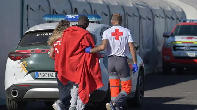 epa11628786 A rescued migrant (C) is assisted by members of the Red Cross after arriving with 59 others by their own means on board a small wooden boat that departed from Mauritania, at La Restinga harbor in El Hierro island, Canaries, Spain, 27 September 2024. EPA/GELMERT FINOL