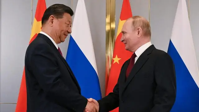 epa11455023 Russian President Vladimir Putin (R) and Chinese President Xi Jinping (L) shake hands as they pose for photos during their meeting on the sidelines of the Shanghai Cooperation Organisation (SCO) summit, in Astana, Kazakhstan, 03 July 2024. The Shanghai Cooperation Organization (SCO) summit takes place in Astana from 03 to 04 July. EPA/SERGEY GUNEEV / SPUTNIK / KREMLIN POOL MANDATORY CREDIT