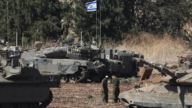 epa11630005 Israeli soldiers stand next to and on their tanks at a gathering point in northern Israel, 28 September 2024. The Israeli army (Tsahal) said on 28 September that military forces continue to strike infrastructure sites of the Hezbollah organization in Lebanon. The army struck over 140 Hezbollah targets since midnight 28 September, including launchers aimed at Israeli civilians, and buildings in which weapons were stored, the report said. Hezbollah leader Hassan Nasrallah was killed in an overnight strike on Beirut, the Hezbollah and Tsahal confirmed in statements on 28 September 2024. EPA/ATEF SAFADI