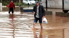 epa09566180 A man crosses a street in the flooded area of Ilidza, Sarajevo, Bosnia and Herzegovina, 05 November 2021. The region has been hit by heavy rains that have caused floods in several areas. EPA/FEHIM DEMIR