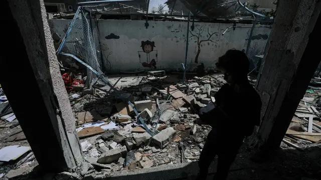 epa11600144 An internally displaced Palestinian boy inspects the rubble at the UNRWA-run school-turned-shelter of al-Jaouni, a day after the structure was hit by an Israeli airstrike, in Al-Nusairat refugee camp, central Gaza Strip, 12 September 2024. According to the Palestinian Ministry of Health in Gaza, at least 18 Palestinians were killed and dozens were injured in the strike. The United Nations agency for Palestine refugees (UNRWA) said at least six of their workers were among the victims. The Israeli military stated that it conducted a 'precise strike' on militants operating inside a Hamas command and control center in the area of Nuseirat in central Gaza. More than 41,000 Palestinians and over 1,400 Israelis have been killed, according to the Palestinian Health Ministry and the Israel Defense Forces (IDF), since Hamas militants launched an attack against Israel from the Gaza Strip on 07 October 2023, and the Israeli operations in Gaza and the West Bank which followed it. EPA/MOHAMMED SABER