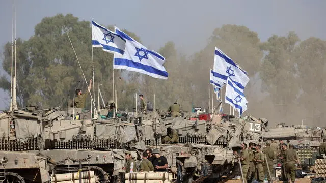 epa11052127 Israeli soldiers with their tanks gather at a position near the border with the Gaza Strip, in southern Israel, 01 January 2024. More than 21,600 Palestinians and at least 1,300 Israelis have been killed, according to the Palestinian Health Ministry and the Israel Defense Forces (IDF), since Hamas militants launched an attack against Israel from the Gaza Strip on 07 October, and the Israeli operations in Gaza and the West Bank which followed it. The Israeli military stated that its ground, air, and naval troops are 'continuing to conduct joint combat' across the Gaza Strip. EPA/ABIR SULTAN