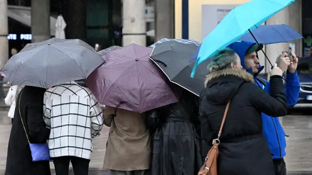 Persone camminano sotto una fitta pioggia in piazza Duomo, 2 novembre 2023. La tempesta atlantica Ciaran pilotata da un profondo ciclone nei pressi delle Isole Britanniche nelle prossime ore sarà in Italia sulle regioni del Nord e su quelle del Centro tirrenico. Perturbato fino a domenica, poi tornerà l'alta pressione. ANSA/DANIEL DAL ZENNARO