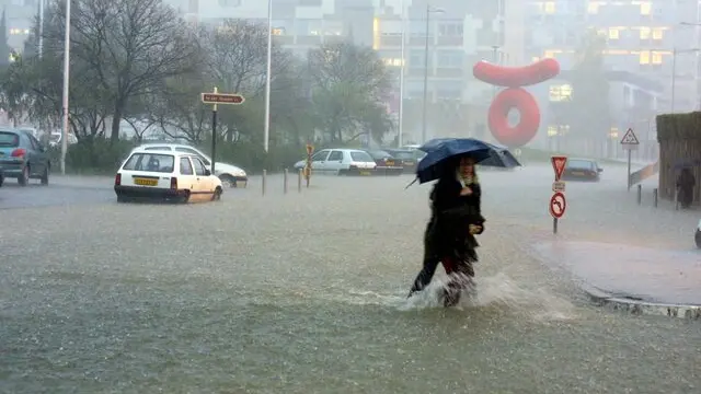 A pedestrian wades through flood water in one of the main thoroughfares of the southern French city of Montpellier Wednesday 3rd December 2003. Continous heavy rain hitting parts of southeastern France threaten to worsen the flash floods that have cost the lives of five people so far and forced about 4,000 people to evacuate their homes. Flooding along the Rhone River from Lyon to Marseille was due to hit its peak during the day, while winds of up to 150 kph were expected to lash the Mediterranean coast, officials said. EPA/CLAVIERES FRANCE OUT