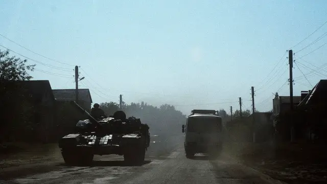 epaselect epa11554386 A civilian bus rides past a Ukrainian tank on a road in the village of Yunakivka, 9 kilometers from the border with Russia in the Sumy region, Ukraine, 18 August 2024 amid the Russian invasion. There is no electricity or water supply in the village due to the permanent shelling by Russian forces. Ukrainian troops have advanced 35 kilometers with battles, taken control of 1,150 square kilometers of the territory of the Russian Federation and 82 settlements since the beginning of the operation in the Kursk region on 06 August 2024 according to the report of the Commander-in-Chief of the Ukrainian Armed Forces Oleksandr Syrskyi at the meeting of the Staff on 15 August 2024. Russian troops entered Ukrainian territory on 24 February 2022, starting a conflict that has provoked destruction and a humanitarian crisis. EPA/GEORGE IVANCHENKO