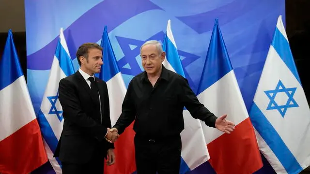 epa10935442 Israeli Prime Minister Benjamin Netanyahu (R) welcomes French President Emmanuel Macron before their talks in Jerusalem, 24 October 2023. Macron is traveling to Israel to show France's solidarity with the country and further work on the release of hostages who are being held in Gaza. EPA/CHRISTOPHE ENA / POOL MAXPPP OUT